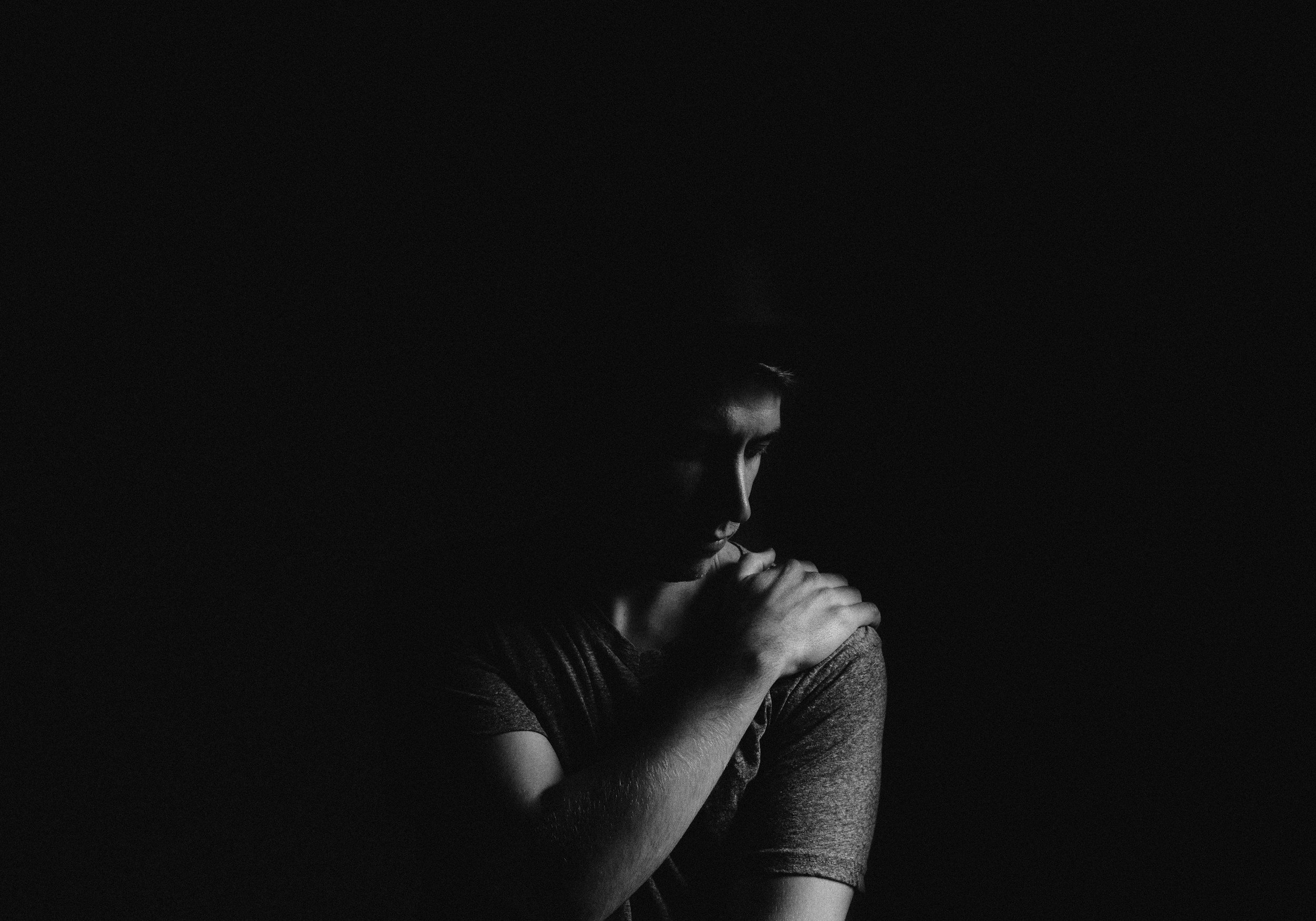 man sitting alone in the darkness